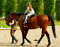 רכיבה טיפולית - ילדה רוכבת על סוס עם מדריכת רכיבה