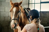 מהי רכיבה טיפולית על סוסים אישה מחזיקה סוס