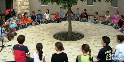 ילדים יושבים במעגל מתופפים עם יוסף המתופף