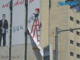 תליית שלטים באמצעות סנפלינג על בניין גבוה בכניסה לעיר ירושלים